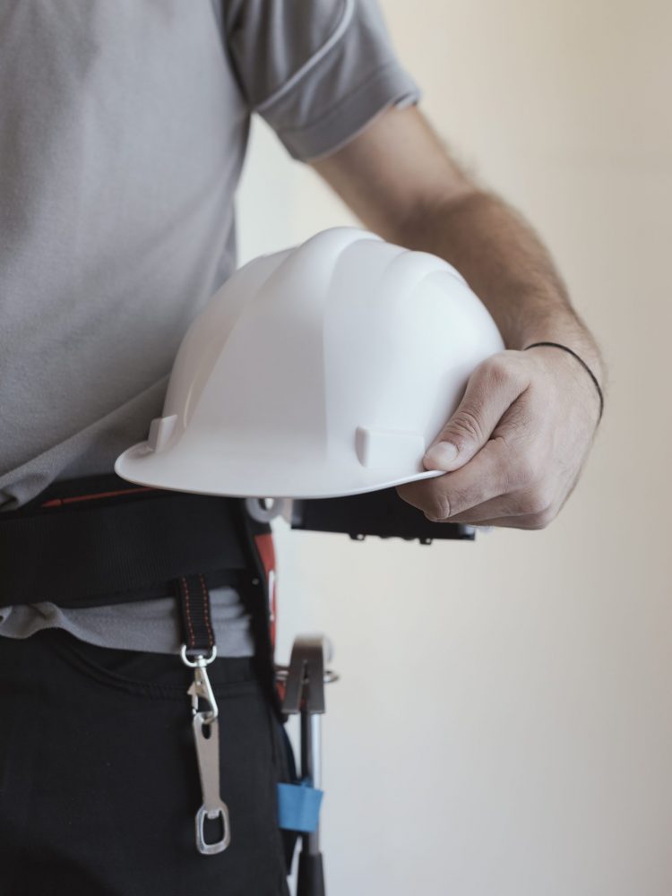 Construction worker holding a safety helmet: construction and workplace safety concept